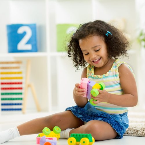 Kid girl playing toys at home or kindergarten Kid girl playing toys at home or kindergarten