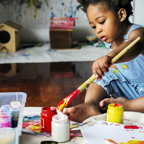 Black kid enjoying color painting